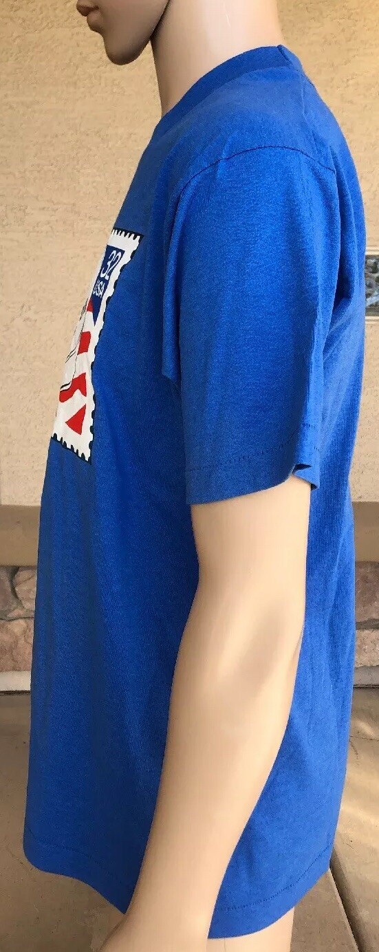 Blue EUC vintage 1995 T-shirt with white POW MIA logo and red, white, and blue stars on chest, worn on side.