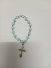 Light blue beaded cross bracelet with secure clasp, elegant durable.