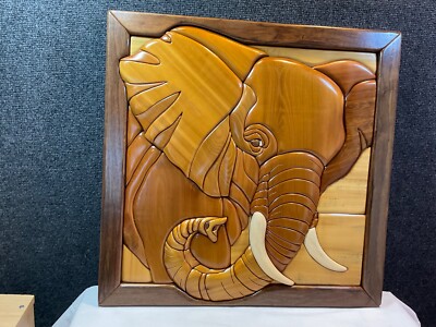 Hand crafted solid wood intarsia wall hanging featuring an elephant head