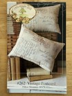 White vintage postcard pillow with handwritten script and envelope design, displayed on black fabric with “Crabapple Hill” label.