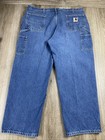 Blue denim Y2K Carhartt men’s carpenter jeans with faded thighs, two front pockets, and visible Carhartt logo on waistband.