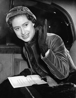 Princess Margaret gives a hand salute from seat of her car after v- Old Photo