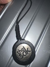 The Sak Hangtag Purse Charm Round Wood Silver Looking medallion Black Cord