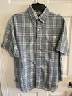 Men’s long-sleeve button-up shirt with green, purple, and yellow plaid pattern and chest pocket, hanging on black hanger.