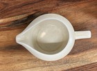 Light gray ceramic coffee mug with white handle, tan interior, and subtle speckled beige K9 logo on wooden surface.