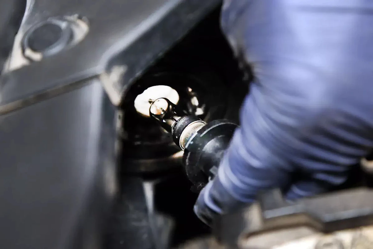 Carefully installing the headlight bulb into the housing.