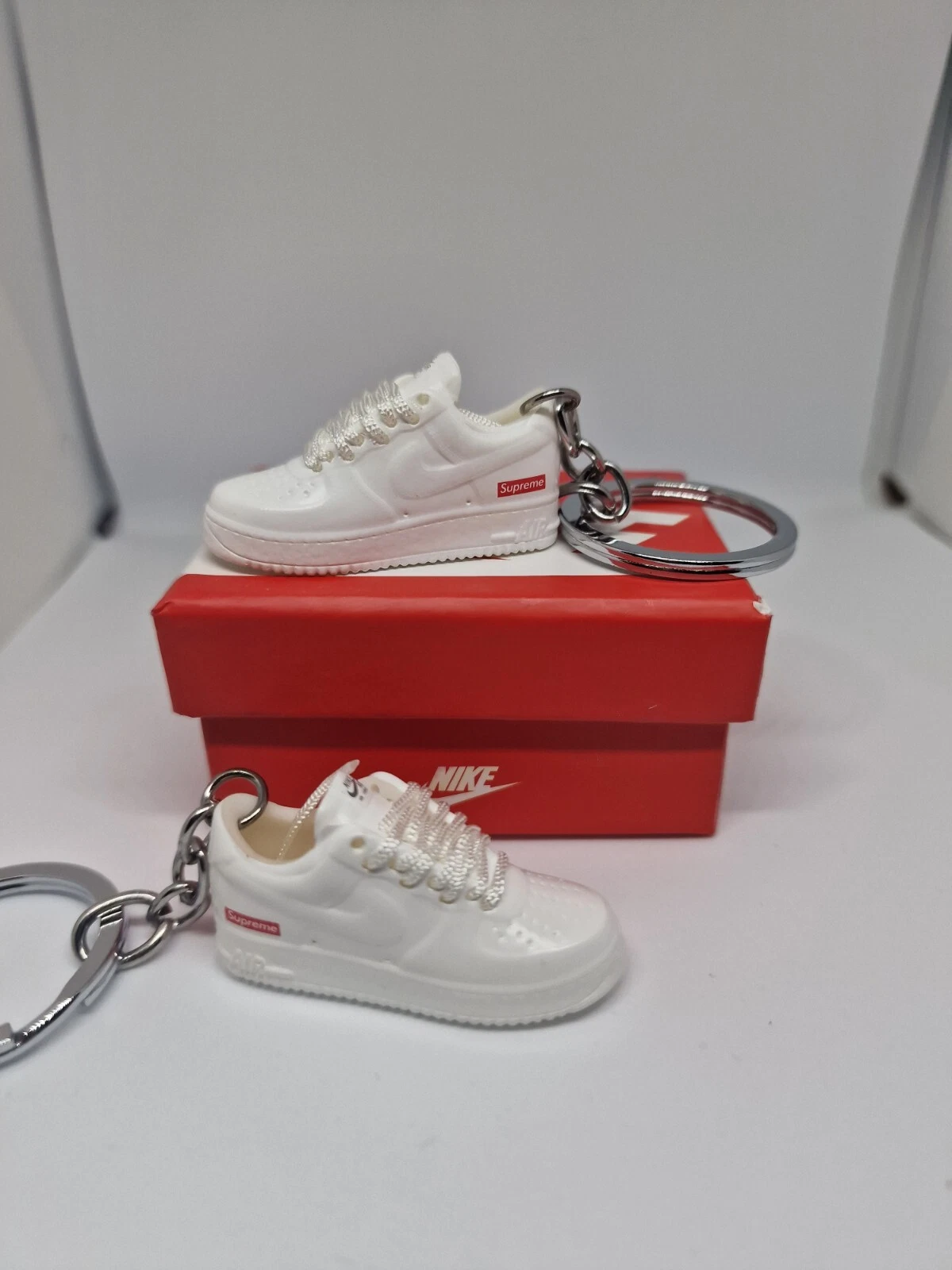 Paire et boîte porte clés blancs Supreme Nike AF1