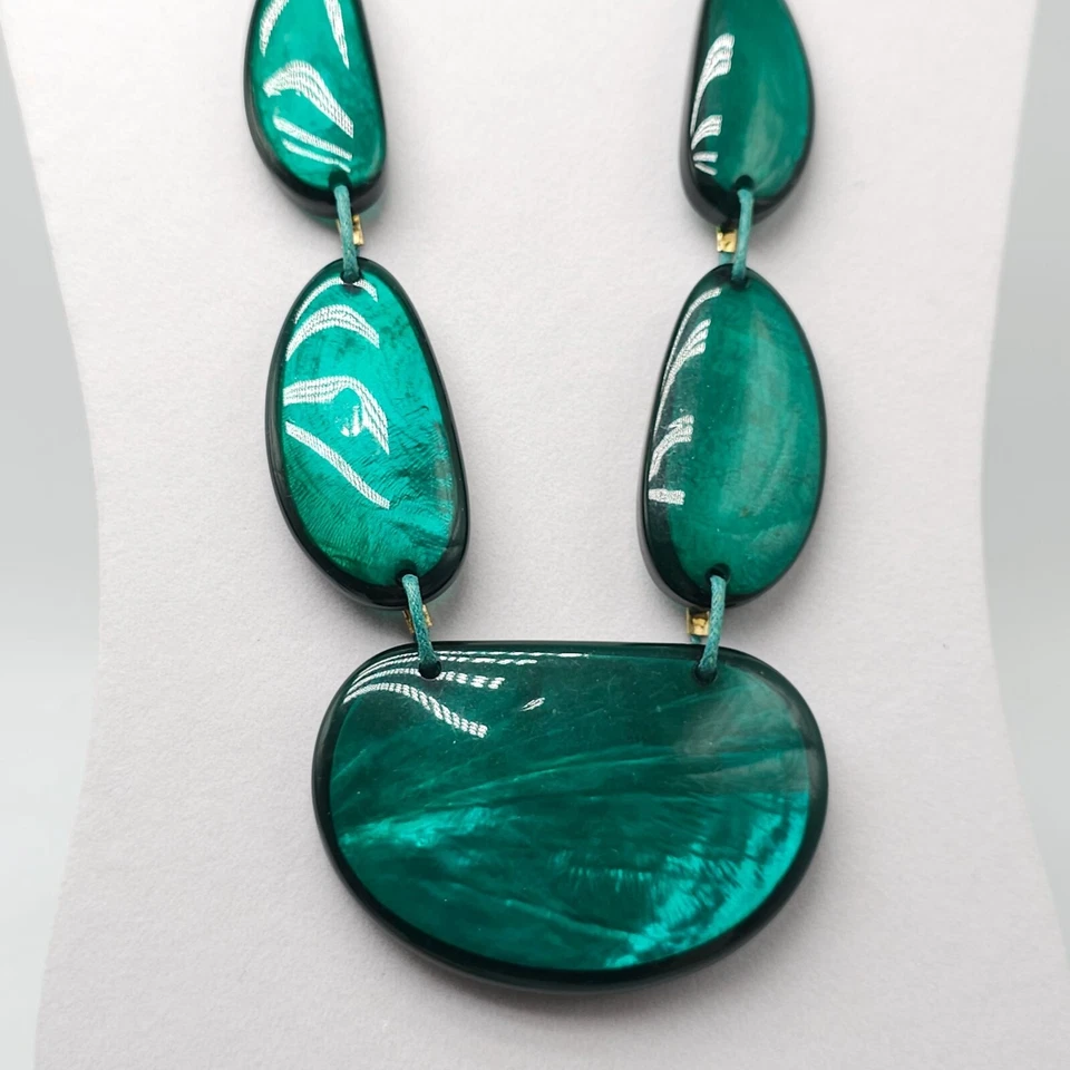 Collar artesanal de resina verde con cordón ajustable y detalles en tono dorado Foto 2 de 4