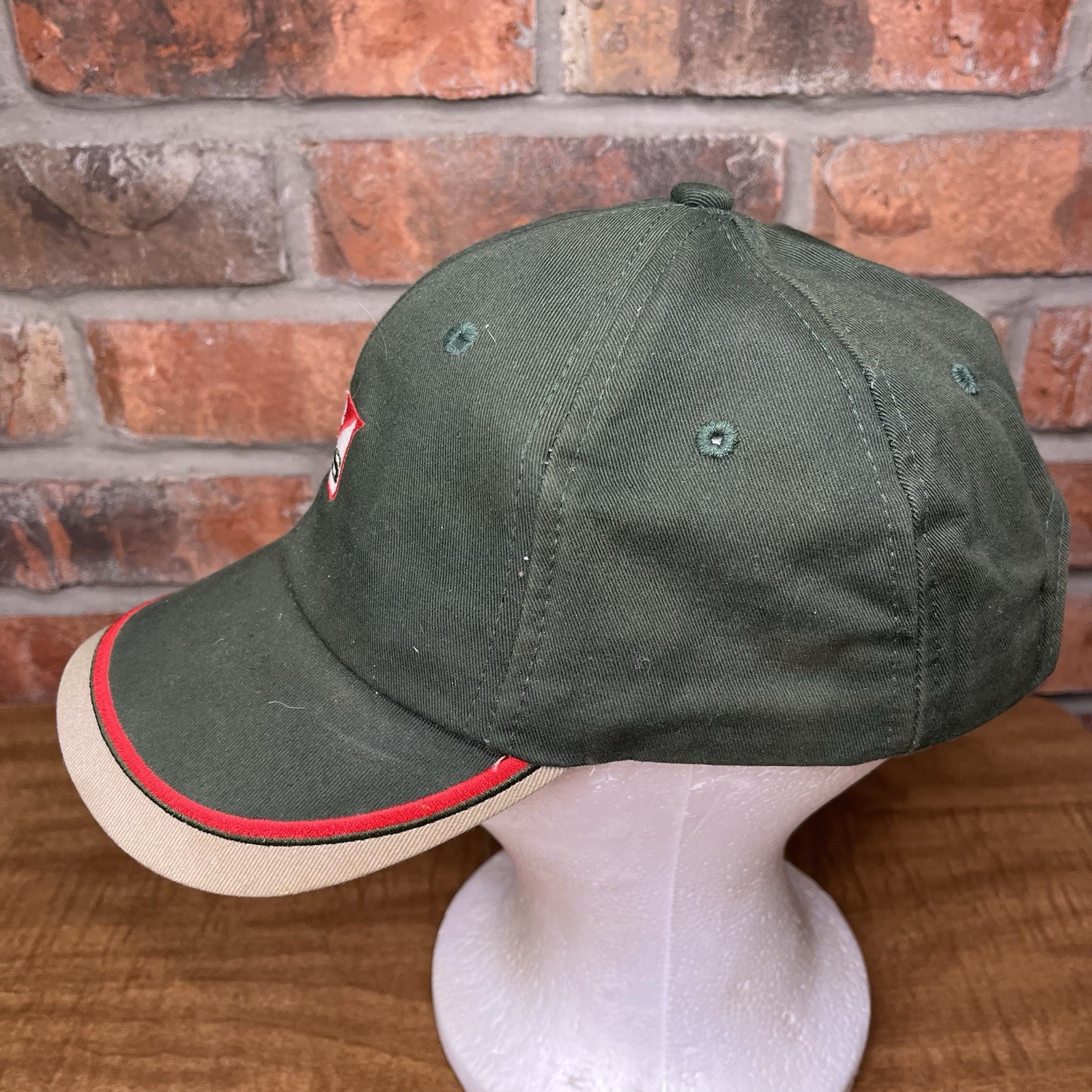 Green vintage baseball cap with red and white stripe, embroidered “K-Products USA Made” text, and red and white logo on front.