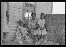 Photo:1938 Sharecropper Family on Porch of Cabin Hay Bale Storage Absence