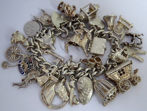 Vintage 102.5g solid silver charm bracelet,many curious silver charms inc moving