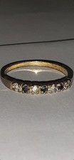 gold-tone half eternity ring with round-cut gemstones.