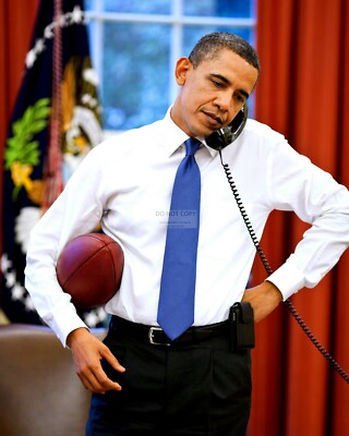 BARACK OBAMA ON THE PHONE WHILE HOLDING A FOOTBALL - 8X10 PHOTO (ZZ-622)