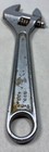 Silver 6-inch adjustable crescent wrench with worn handle, yellow “MFD. IN U.S.A.” text, and two metal screw heads.