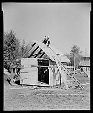 Orville White building a small shed on his farm near Northome, Minnesota