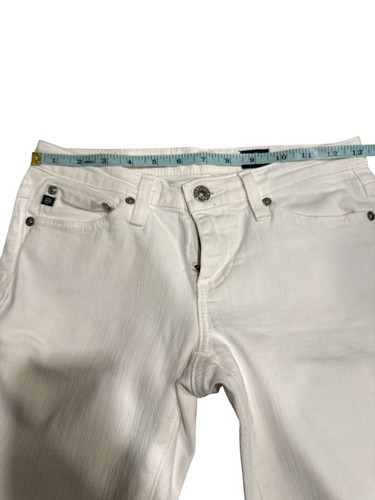 White AG Adriano Goldschmied jeans 25R with button closure, belt loops, and silver rivets, shown on mid-thigh leg.