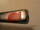 Vintage Playtex hair cutter with red plastic handle, silver bowl, and engraved text “Made in U.S.A.” on side.