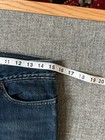 Dark wash VTG 1990s Levi’s Superlow 518 bootcut jeans, waist 31, on hanger with measuring tape.