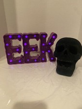 Velvet black skull and lighted purple EEK sign