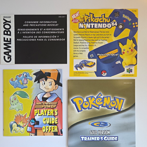Gold Pristine CIB Game Boy with dual screens, Pikachu logo, and colorful Pokémon Trainer’s Guide.