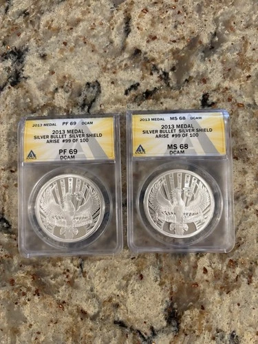 Silver Bullet Silver Shield 2013 Arise 99 of 100 Graded  Error Anacs 2 coin set