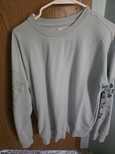 Maurices light blue sweatshirt, features distinctive floral on the sleeves.
