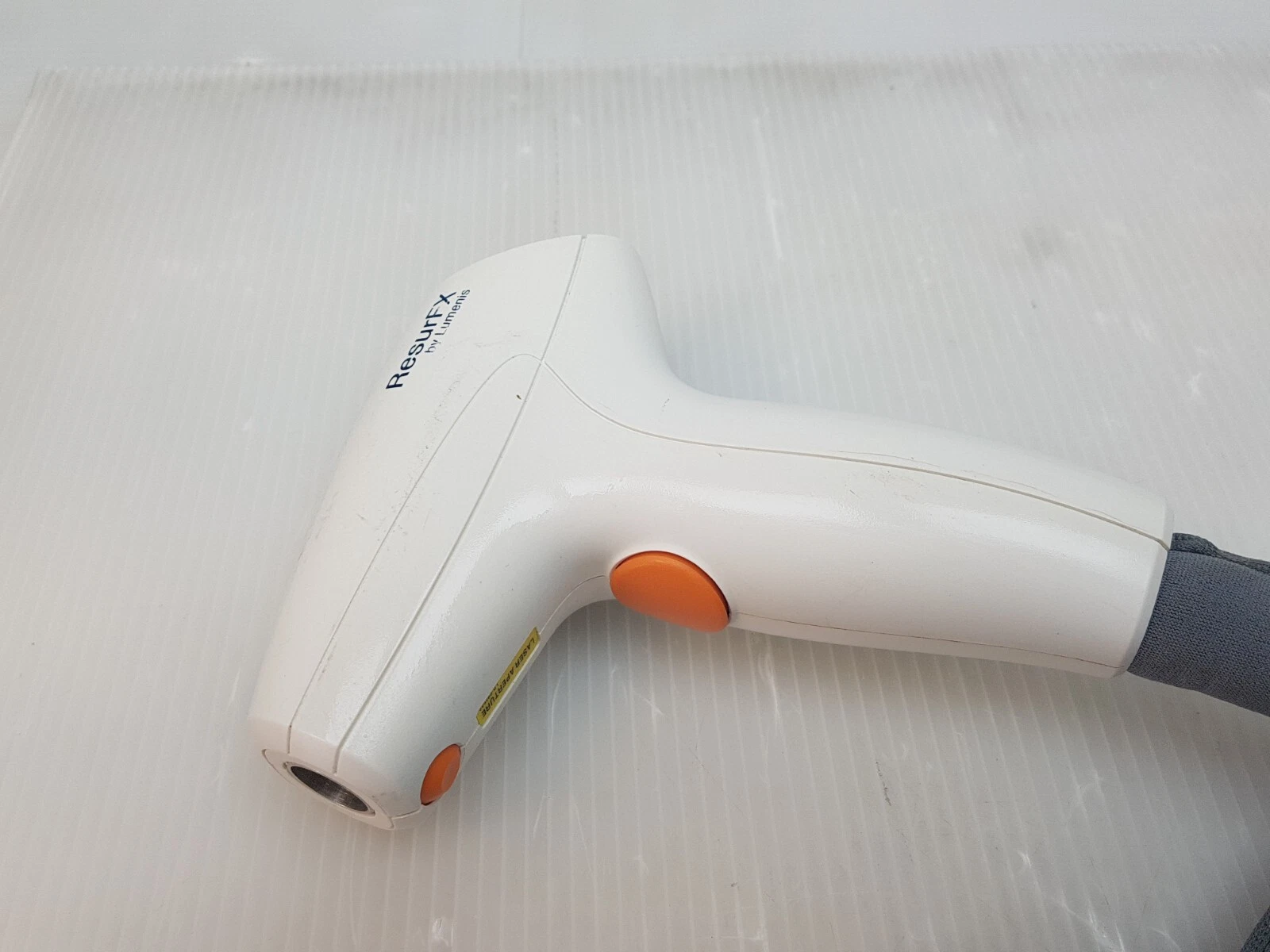 ResurFX handpiece, logo side, with orange buttons