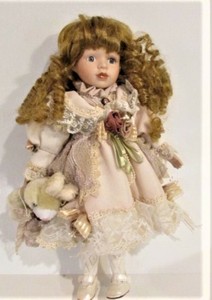 porcelain doll with blonde hair and blue eyes