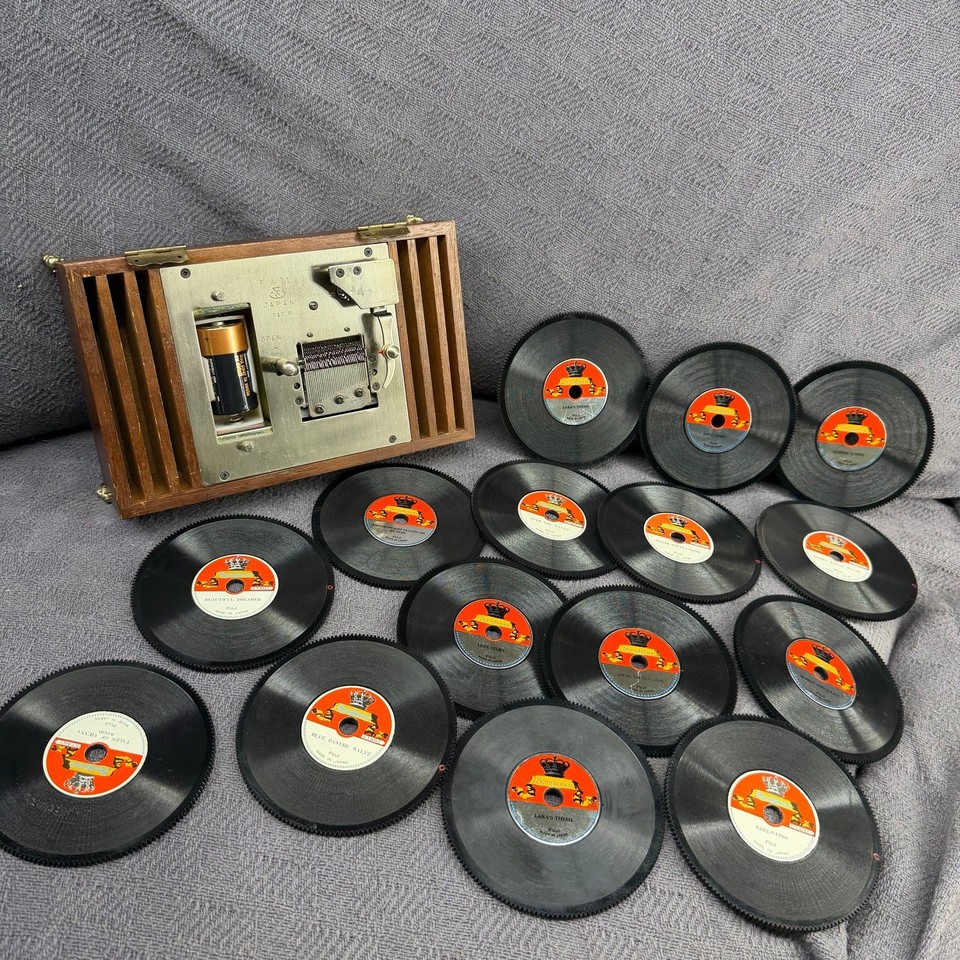 A genuine Symphonion-style disc music box with 15 metal discs — this is a pre-digital jukebox that plays interchangeable steel discs like a 19th-century streaming service.