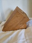 Cutco solid honey oak wood knife storage block with 13 slots, resting on a white fabric surface.