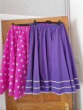 1 pink with white spots flared skirt, 1 purple flared skirt with silver braiding