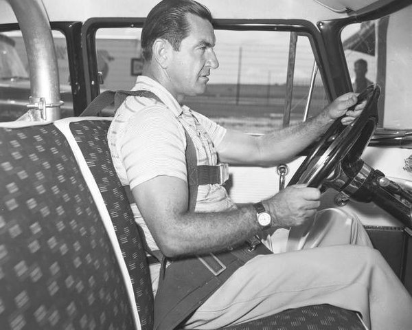 Driver Frank Mundy demonstrates an early safety belt configuration- Old Photo