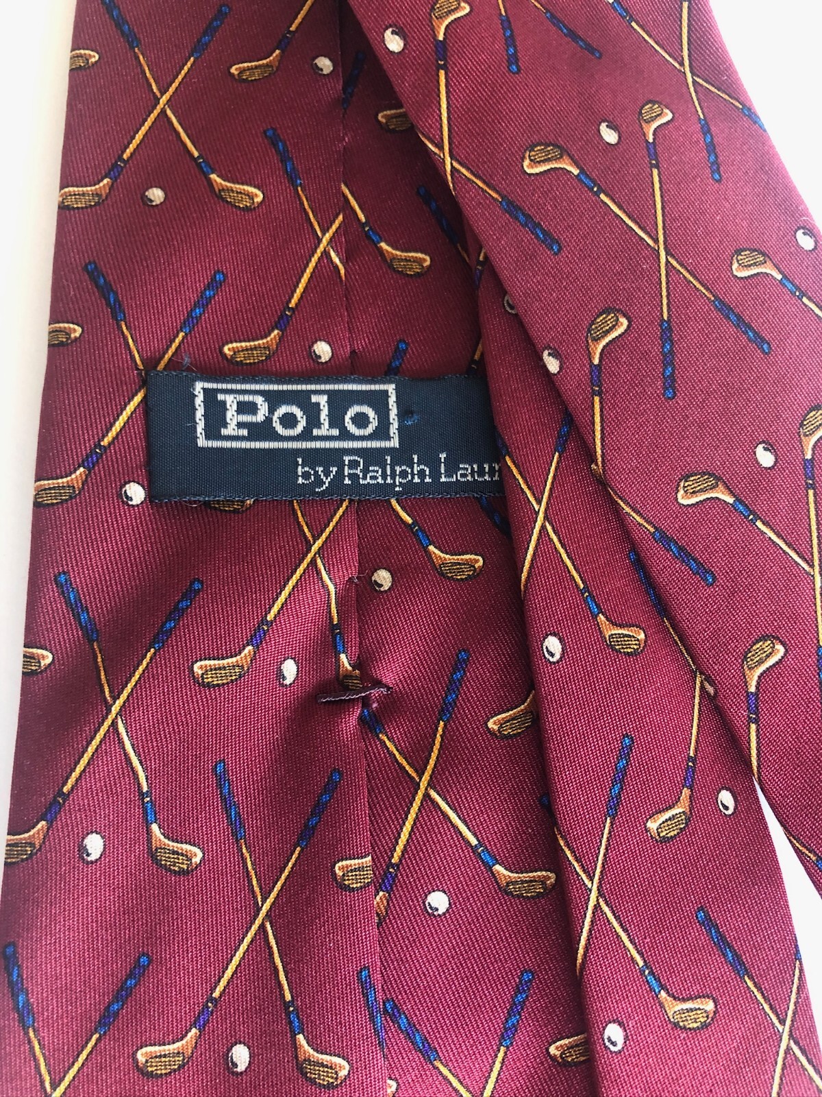Burgundy silk tie with gold embroidered golf clubs and “Polo Ralph Lauren” text, 56 inches long.