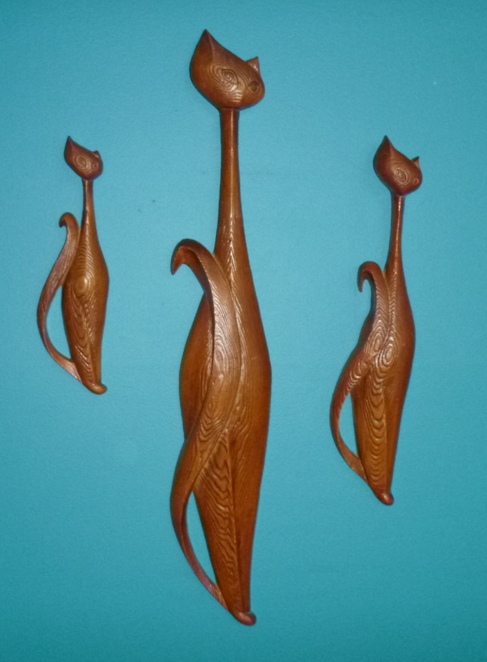 A rare trio of Sexton cast-metal stylized cat wall sculptures with woodgrain texture — MCM kitsch at its absolute peak, and a genuine conversation-starter.