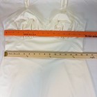White nylon full slip with sheer mesh trim, fitted bodice, and long sheer skirt, displayed flat with orange ruler.