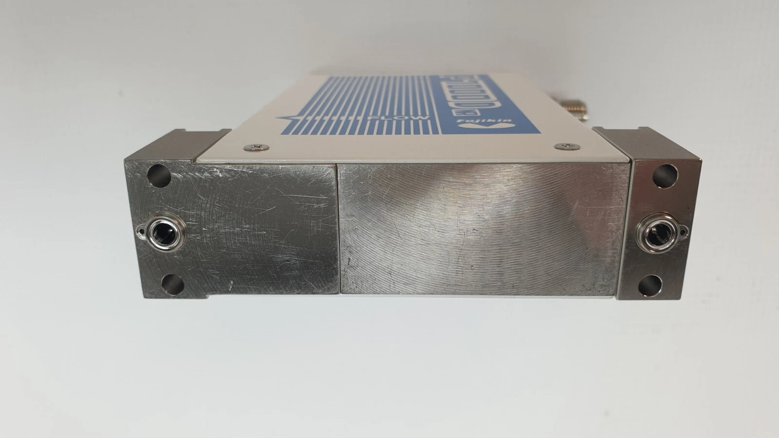 Surface-mount base of the Fujikin FCSP7202DW-4CW2-F1300-8 showing the two gas ports