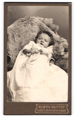 Fotografie Gustav Schmidt, Leck, Bahnhofstrasse, Süßes Kleinkind auf Fell 