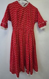 This vintage 1950s red dress features a Dutch heart print and delicate white lac