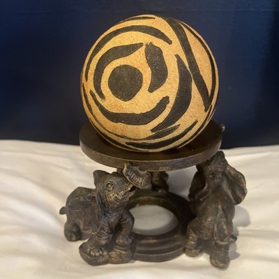 Three Circling Elephants Holding A Sphere