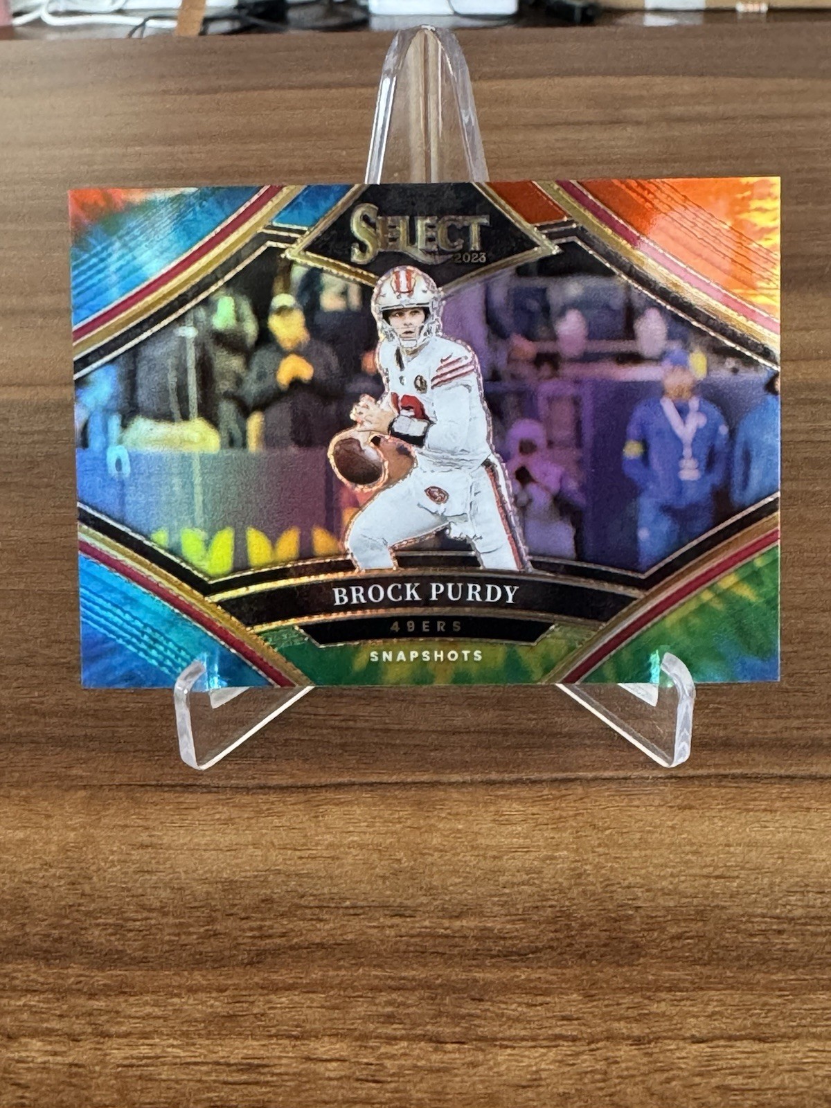 2023 Panini Select - Snapshots Brock Purdy #SS-BP Tie-Dye Prizm /25