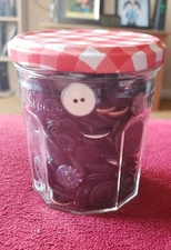 Black, gray and silver buttons in a jam jar Various sizes, shapes, and materials