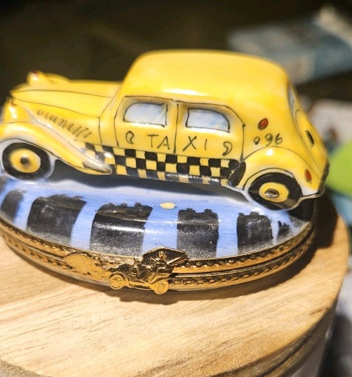 Hand-painted, artist-signed Limoges porcelain taxi cab box — a collectible miniature that doubles as a one-of-a-kind NYC-nostalgia gift.