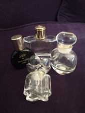 Lote de cuatro botellas de perfume vintage Joy, Emeraude, Oscar De La Renta vacías