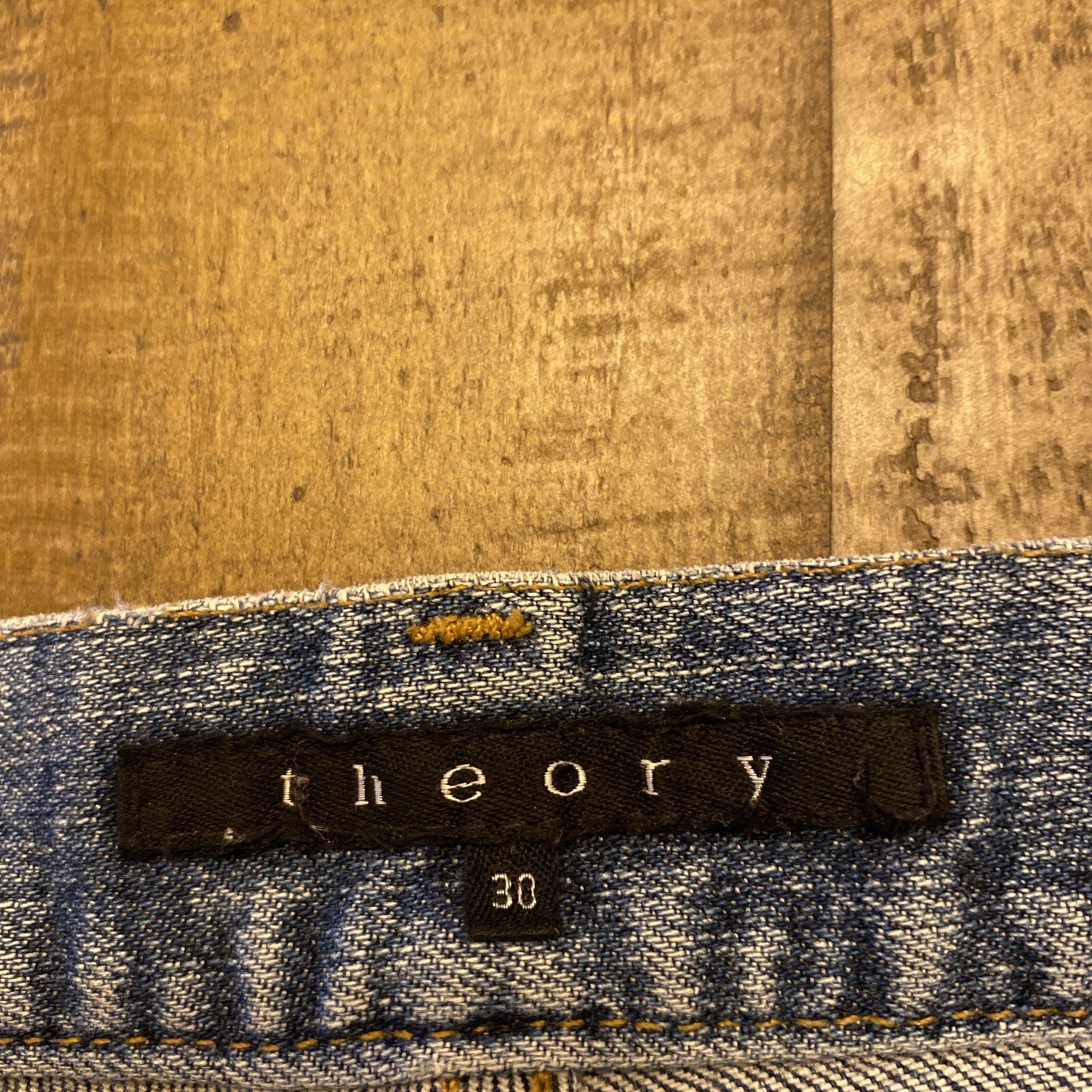 Blue denim Theory mens stretch pants, size 30x33, with yellow printed brand label and black size marker on waistband.