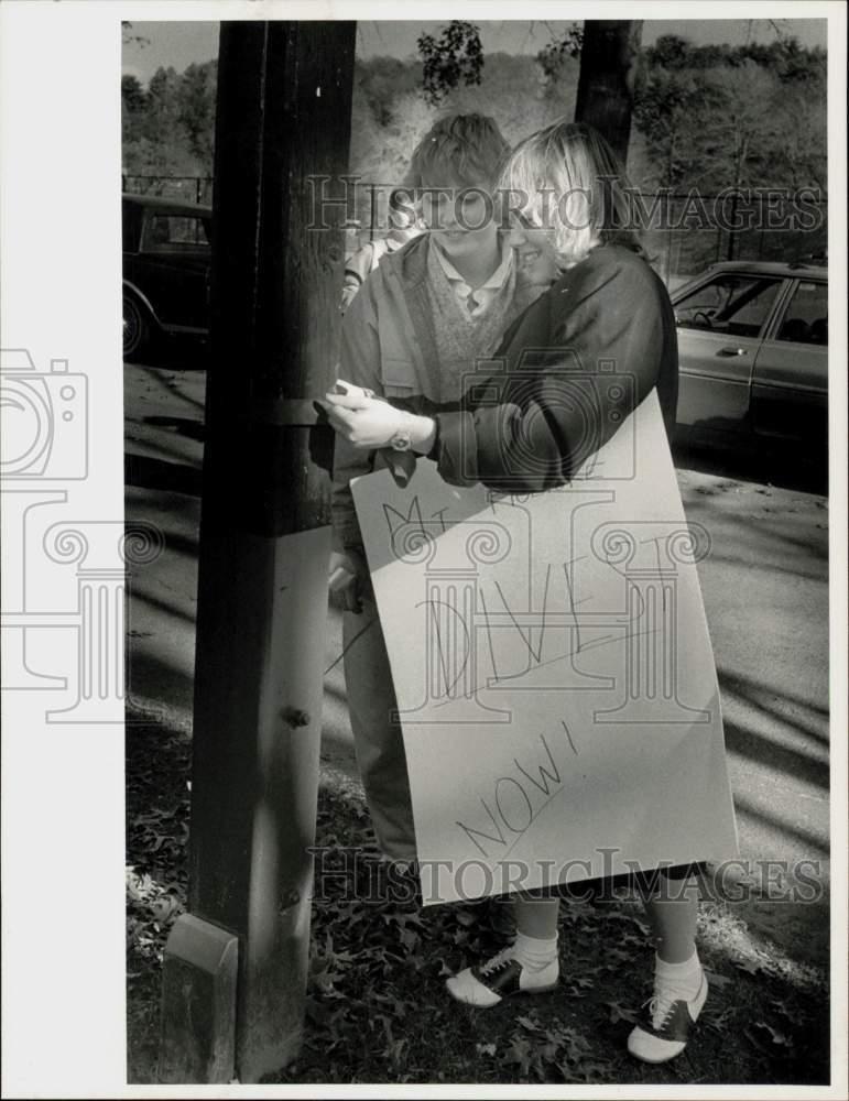 Press Photo Mt. Holyoke College students tape Anti-Apartheid posters on pole.