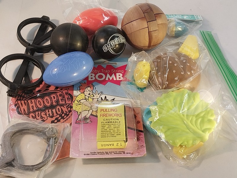 Set of party gag gifts. Silly Putty. Wood puzzle. Whoopie cushion. Pull firework