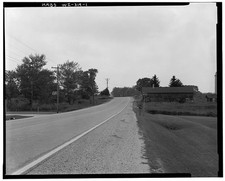 1. GENERAL VIEW WEST. SUBJECT PROPERTY LEFT & OBSCURED TREES. OUTBUILDINGS