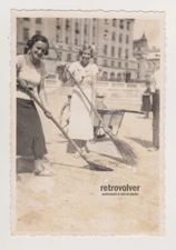 Two Lovely Young Women Sweeping the Street with Joyful Smiles and Laughter Photo