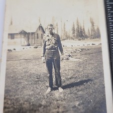Hombre en pantalones elegantes de pie afuera edificio rústico cabaña bosque rural foto de colección