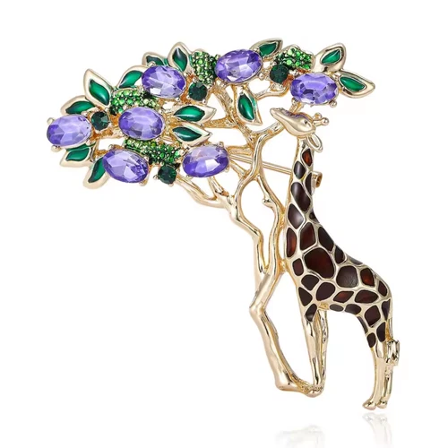 Gold-tone giraffe brooch with spotted pattern, green leaves, and round purple crystals on a branch.